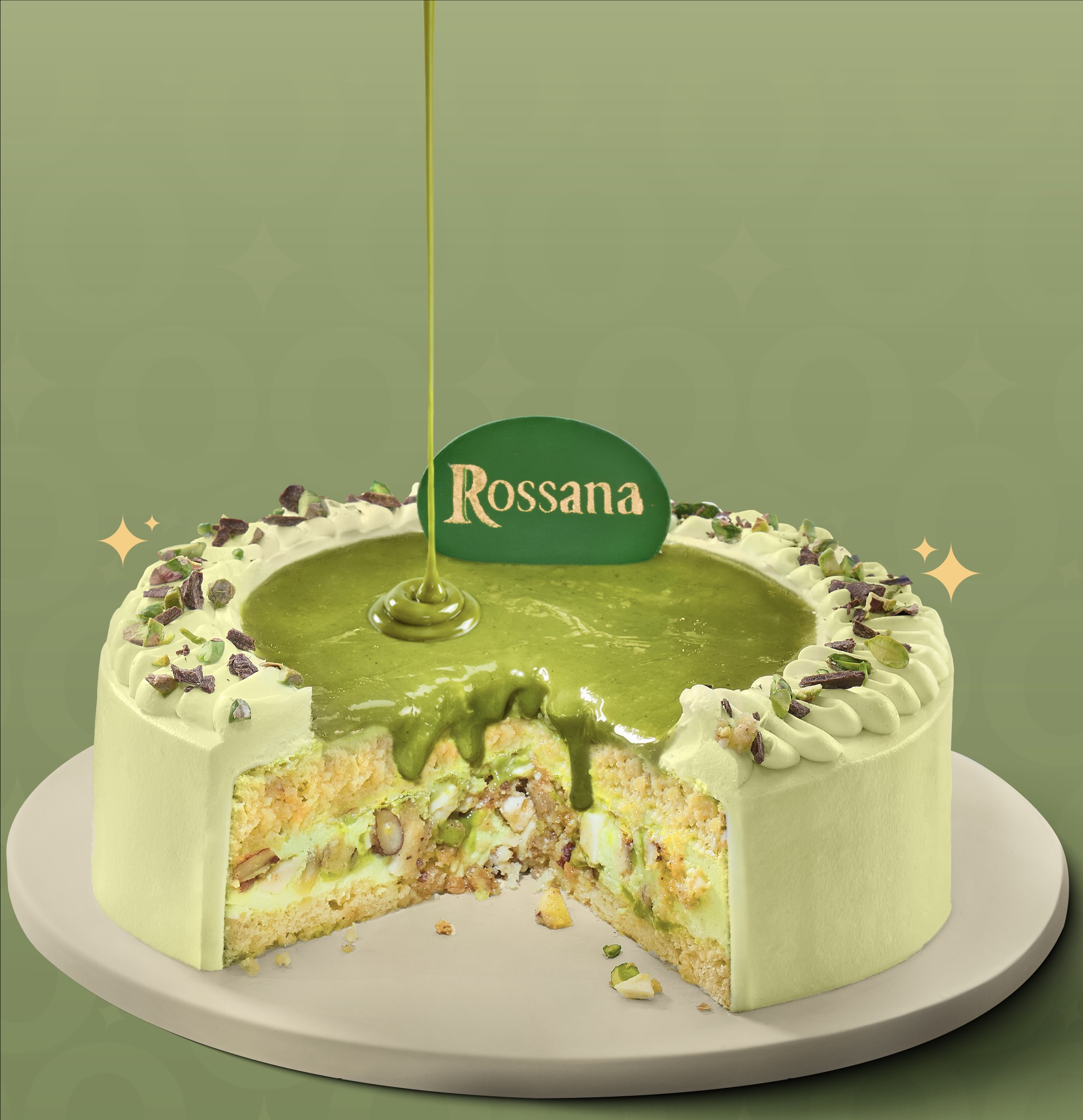 Torta Rossana Pistacho de Spoon servida en un plato, con una porción cortada y salsa de pistacho cayendo sobre la cubierta